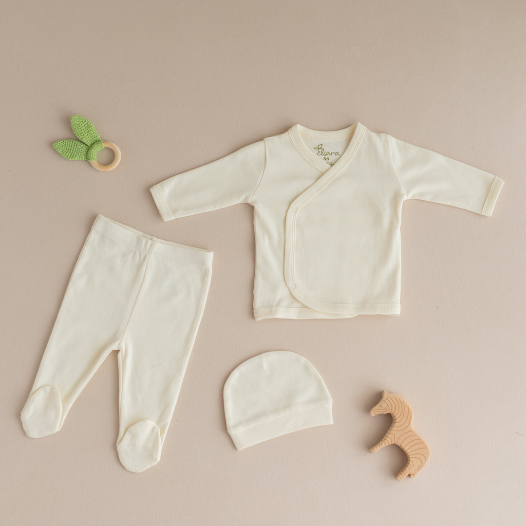 Vegane Bio-Babymode Set cremefarben mit Langarmshirt, Hose, Mütze und Holzspielzeug von Elsara